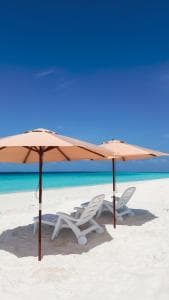 A parasol on the beach above the turquoise shallows
