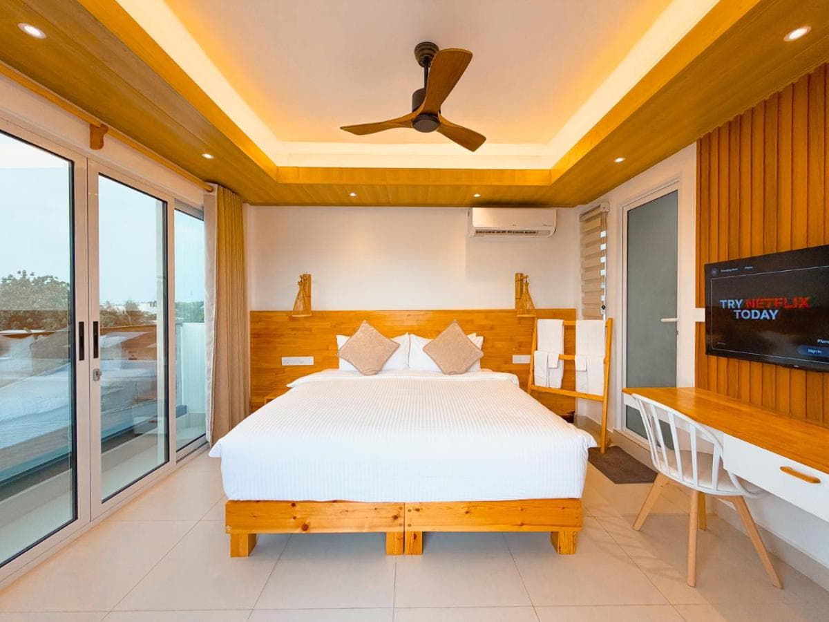 Deluxe Double Room with its balcony doors open to the sea